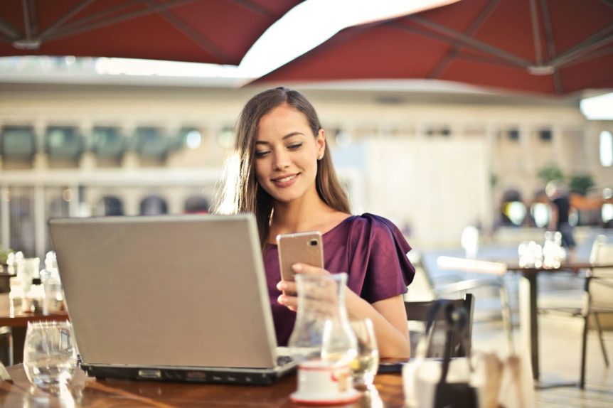 woman sat with phone and laptop